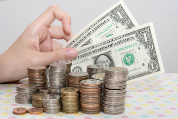 Wall Mural - Buying concepts present by Female hand showing banknotes behind money coin stacks isolated on white, Money, Financial, Business Growth concepts