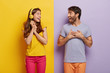 © WHstudio Leushin N - Cheerful smiling woman with headphones, feels excited and happy, looks at boyfriend, clasp hands, dressed in casual outfit, hear good news, rejoice something awesome. Positive emotions concept