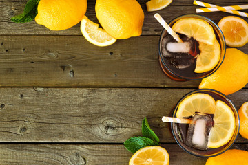 Wall Mural - Sweet summer iced tea. Top view corner border with copy space on a rustic dark wood background.