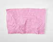 © nndanko - crumpled pink rectangular sheet of paper on a white background