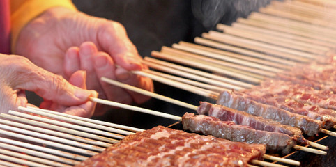 woman and raw meat called Arrosticini in Italian Language