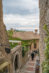 People walk down a narrow street in Eze, France