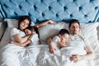 © Тарас Нагирняк - Top wiev of sleepy family with children lying on bed..