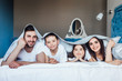 © Тарас Нагирняк - Young family resting together in parent's bed under blanket.