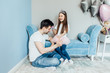 © Тарас Нагирняк - Bearded man and little girl at home family time sitting on carpet , daughter making hairstyle for father using hair bands smiling joyful..