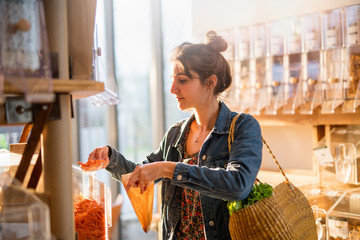 Beautiful young woman shopping in a bulk food store.