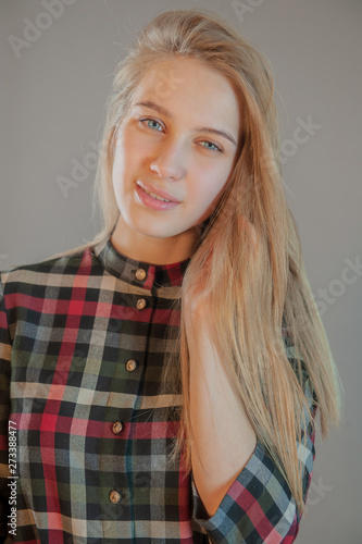 Beautiful Blonde With Blue Eyes In Plaid Dress Touches Her Hair