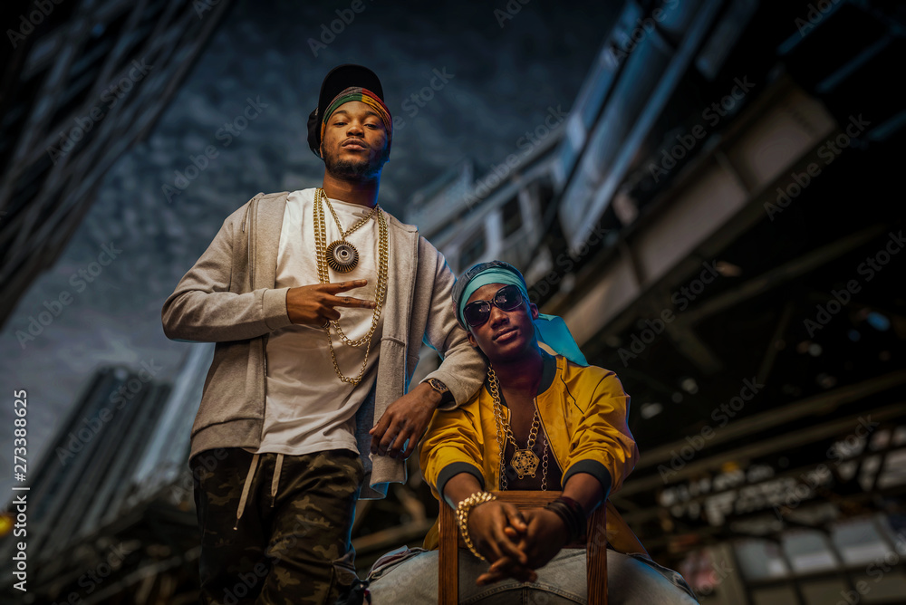 Two black rappers poses on night city street - obrazy, fototapety, plakaty 