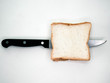 © scentrio - Sliced Bread with knife on white background.