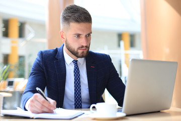 Wall Mural - Portrait of young man sitting at his desk in the office.