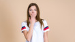 © brizmaker - Young worried woman standing on pastel beige background and holding palm hand near face