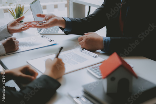 couple buying renting house signing mortgage contract agreement with realtor real estate agent Obraz na płótnie