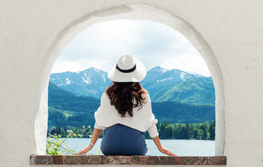 Traveling in Europe, Young woman in white hat looking at beautiful mountain with lake view at Austria in summer