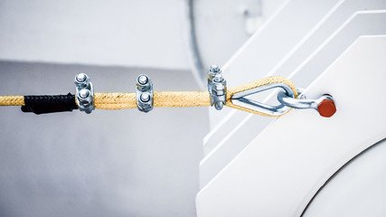 Close up of a yellow nylon rope fastening to a metal structure