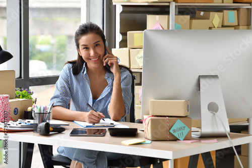 Cuadros en Lienzo Young Asian woman entrepreneur/ Business owner working with computer at home