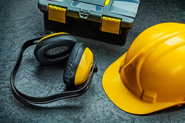 earphones helmet and tool box on black background