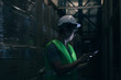 © twinsterphoto - Side view of Asian young warehouse worker man with safety hard hat is checking order details with a digital tablet at inventory room
