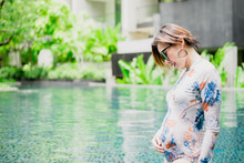 Beautiful Pregnant Woman Relaxing Outside In Swimming Pool