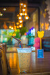 © DSM - Ice coffee in a plastic cup on wooden table with bokeh background.