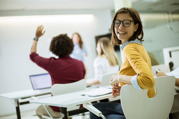 Young female student with eyeglasses in the classroom