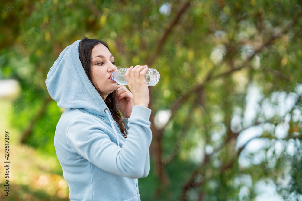 Thirsty woman drinking water after sport activities.Health concept. - obrazy, fototapety, plakaty 