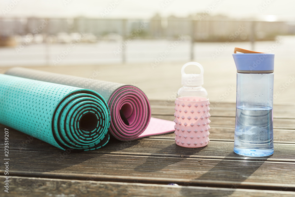 Background image of yoga mats and water bottles set for workout on wooden pier outdoors, copy space - obrazy, fototapety, plakaty 