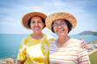 Two elderly Asian women are friends who go to the sea with happiness in retirement.