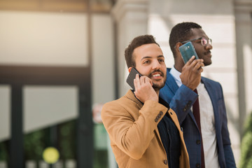 two men in suits are talking on the phone