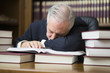 © Minerva Studio - Bored businessman sleeping on books in his office