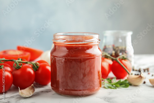 Cuadros en Lienzo Composition with jar of tasty tomato sauce on table against grey background