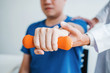 © joyfotoliakid - Physiotherapist man giving exercise with dumbbell treatment About Arm and Shoulder of athlete male patient Physical therapy concept