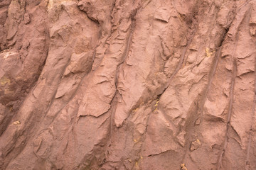 Reddish brown hard soil cracks stripes irregular texture background closeup