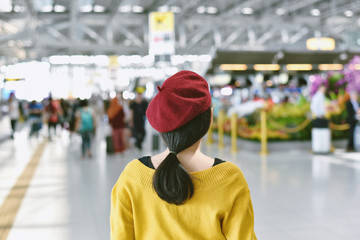 Asian woman standing in trade fair exhibition hall, Blurred background of large crowded people at big event with copyspace.