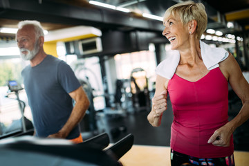 Wall Mural - Fit senior sporty couple working out together at gym