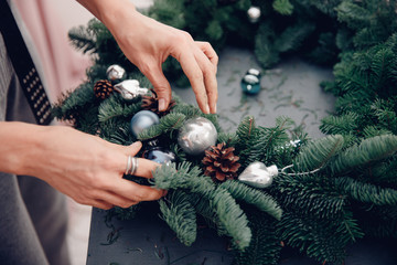 Woman decorating coniferous wreat Christmas tree workshop DIY