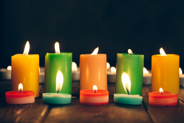 candles burning in darkness over black background. commemoration concept.