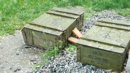 Wall Mural - green wooden boxes of ammunition and shells are on the street in the rain