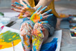 © golubovy - Creative performance. Cropped shot of artist sitting on floor, showing feet and hands dirty with multicolor paint.