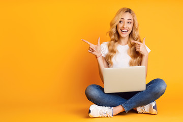 Excited Woman With Laptop Pointing On Copy Space
