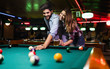 © NDABCREATIVITY - Happy young man playing snooker with his girlfriend. Happy loving couple.