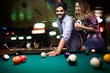 © NDABCREATIVITY - Couple dating, flirting and playing billiard in a pub