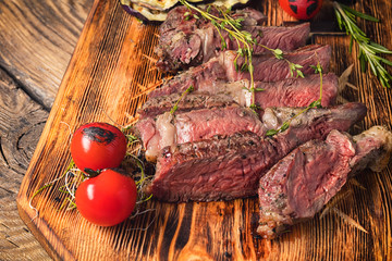 Sticker - medium rare beef steak  on wooden board with herbs.