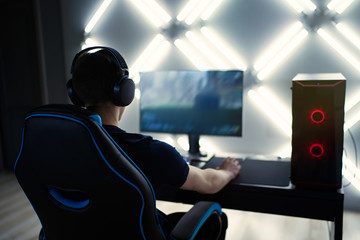 Professional gamer in his expensive studio young man having live stream playing online video game. Cyber sportsman is streaming popular pc computer game for his followers     