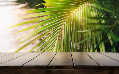 Dark wood table top (Bar) with blur on green palm leaves or tree in tropical forest with bokeh light at background