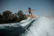 © fesenko - Brunette woman surfs on a surfboard in sea