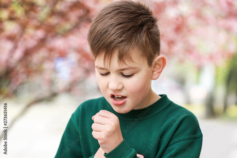 Boy having asthma attack outdoors on spring day