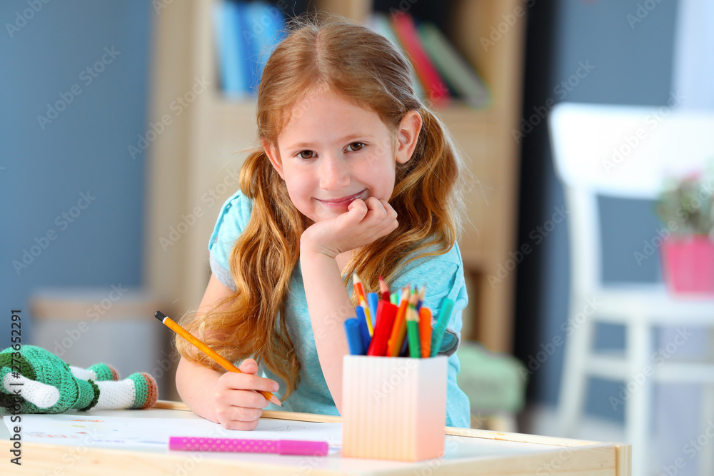 Cute little girl drawing at home