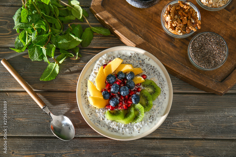 Bowl with tasty chia dessert on wooden table