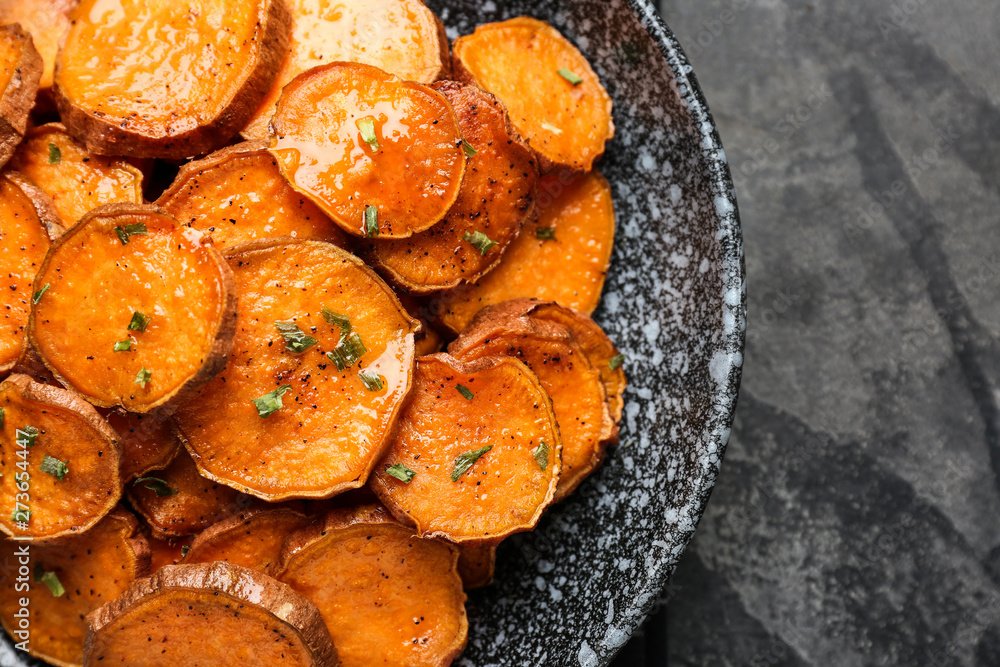 Plate with tasty cooked sweet potato on grey background