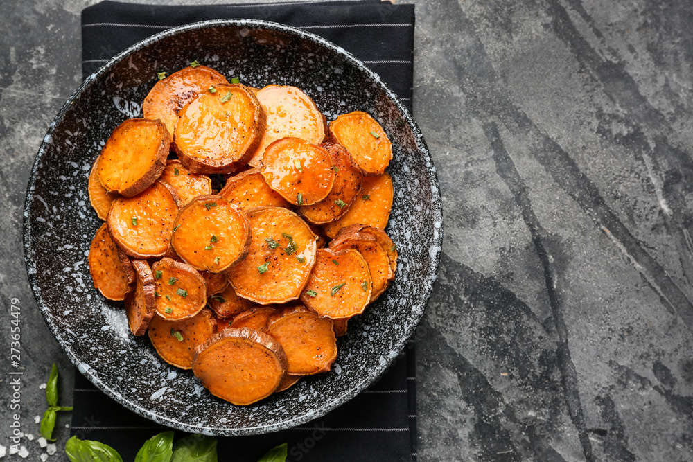 Plate with tasty cooked sweet potato on grey background